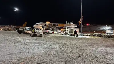 Mean Girls cross load of pallets at Anchorage airport onto airplane for departure for San Francisco